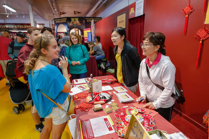 Four people chatting at an information table in U of M Central at the State Fair.